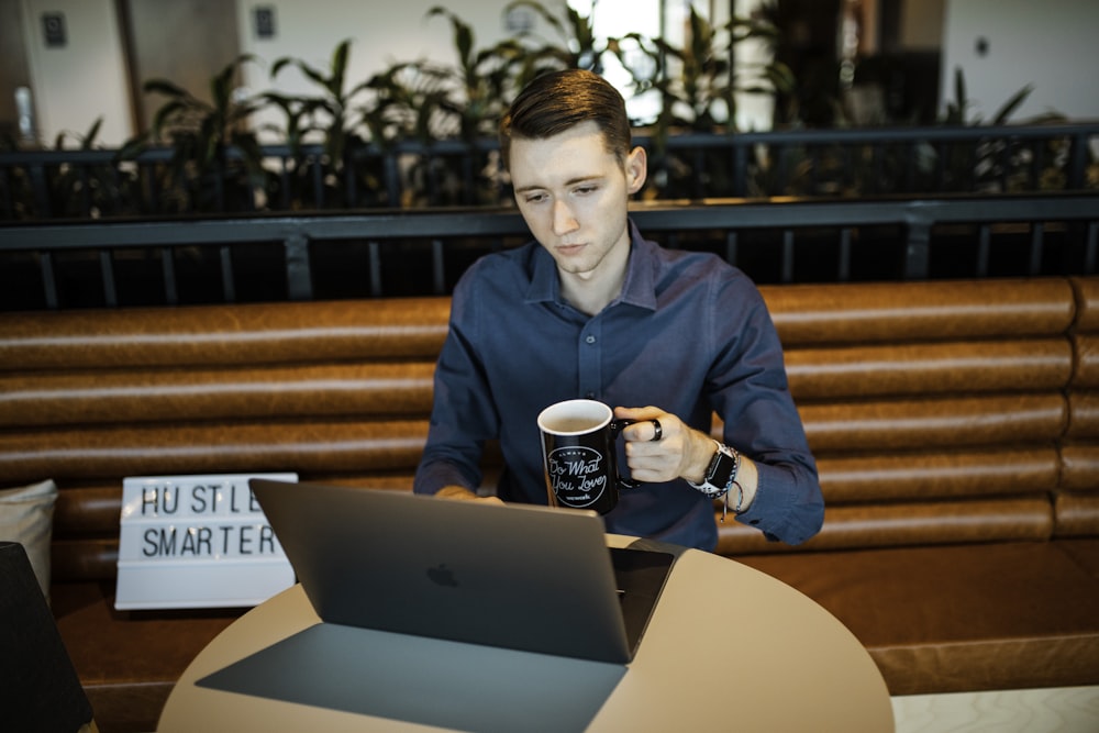 woman in blue blazer sitting on chair while using macbook