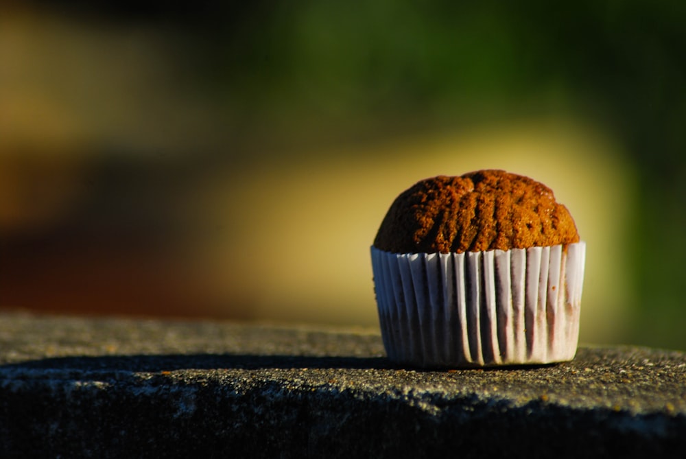 brown cupcake on gray concrete surface