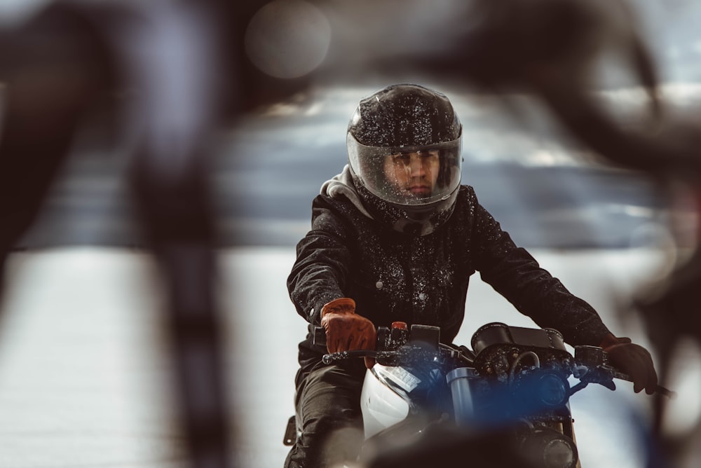 man in black jacket riding blue motorcycle
