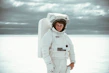 Model wearing white 'Astronaut Alone' jacket against dark backdrop emphasizing minimalist design