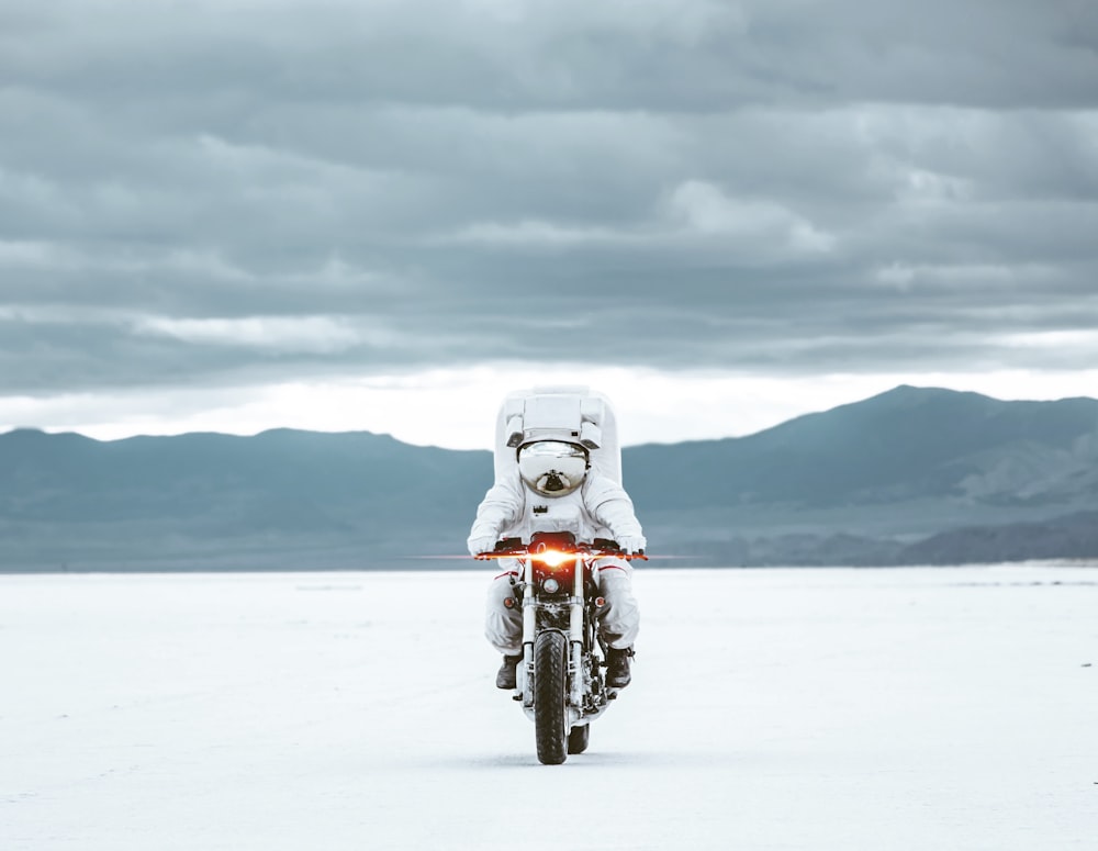 motocicleta branca no chão coberto de neve durante o dia