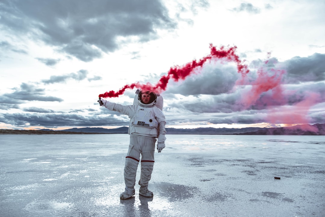 a man in a white space suit holding a red substance,