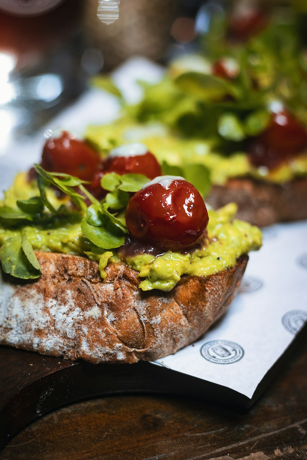 brown bread with green vegetable and red tomato on white ceramic plate