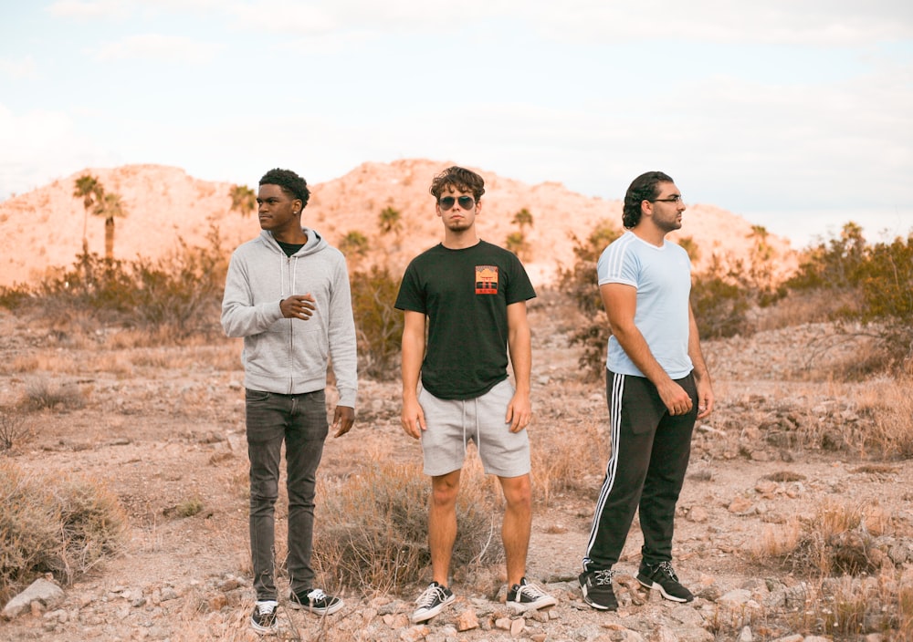 man in black crew neck t-shirt and brown shorts standing beside man in white t