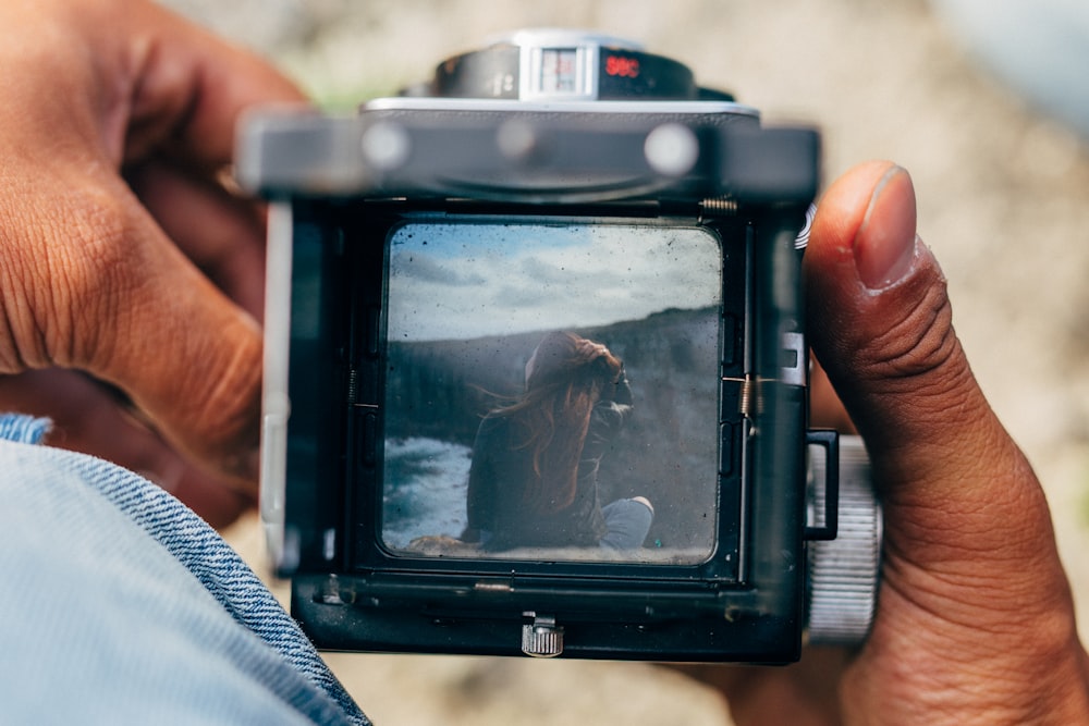 person holding black dslr camera