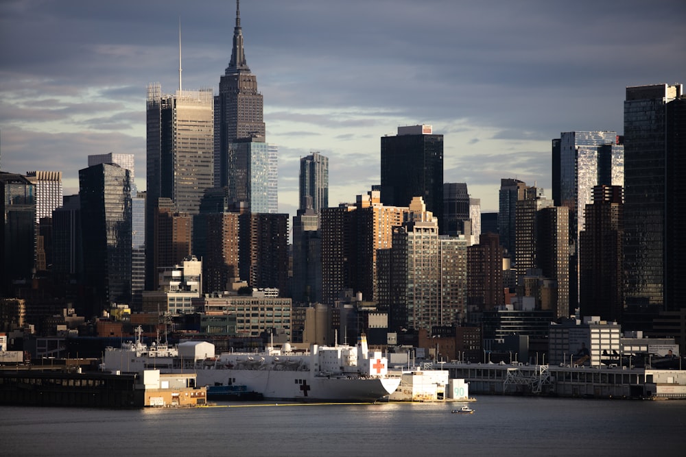 white ship on sea near city buildings during daytime