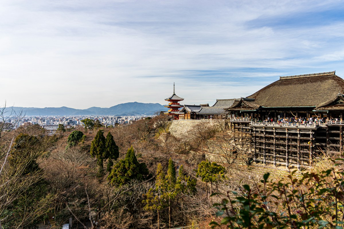 清水寺的木造舞台建於山坡上，遠方是京都市區街景