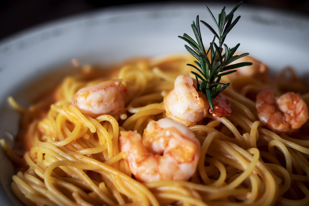 pasta with cream and green leaf on white ceramic bowl