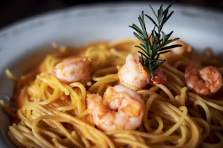 pasta with cream and green leaf on white ceramic bowl