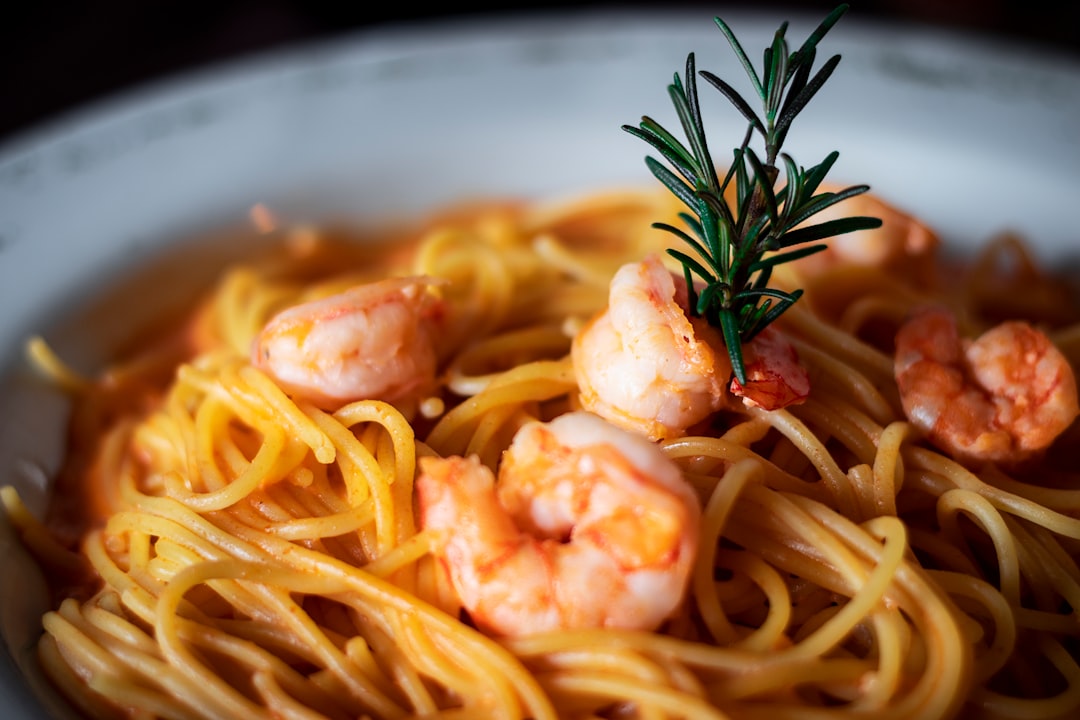 pasta with cream and green leaf on white ceramic bowl