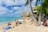 A vibrant beach scene with happy travelers enjoying their vacation.