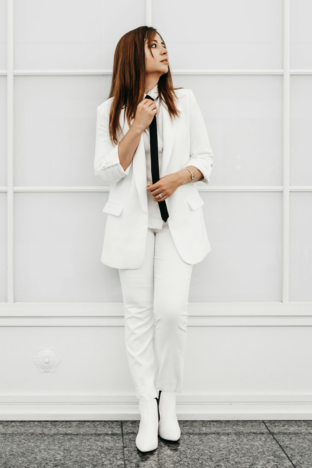 woman in white blazer and white pants standing