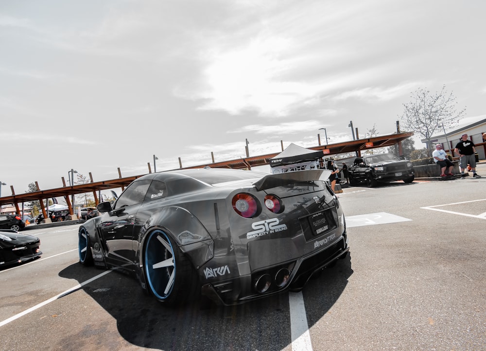 black and red sports car on gray asphalt road under gray cloudy sky during daytime