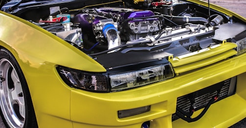 Close-up of a green sports car's engine bay with custom tuning components.