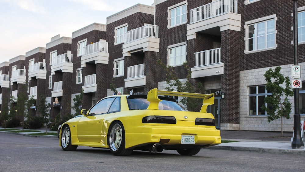 yellow porsche 911 parked near white and gray concrete building during daytime