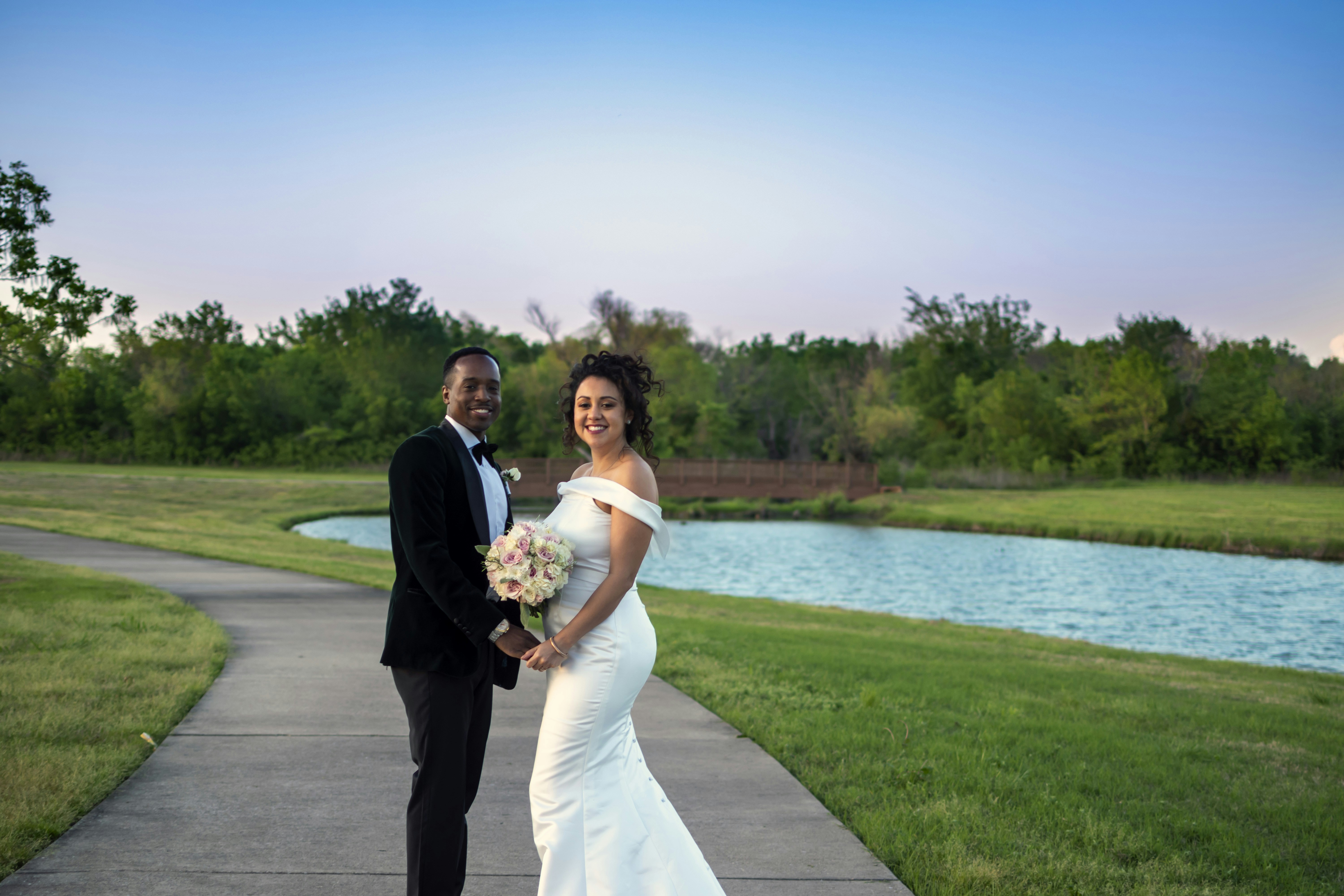 man in black suit and woman in white wedding dress standing on …