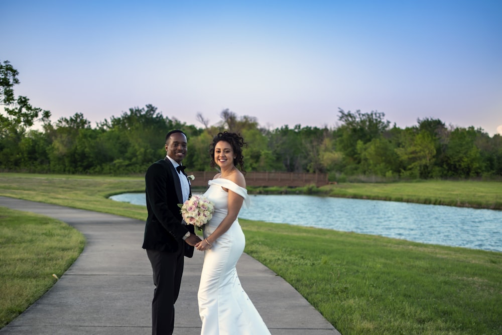 man in black suit and woman in white wedding dress standing on gray concrete pathway near near near near near