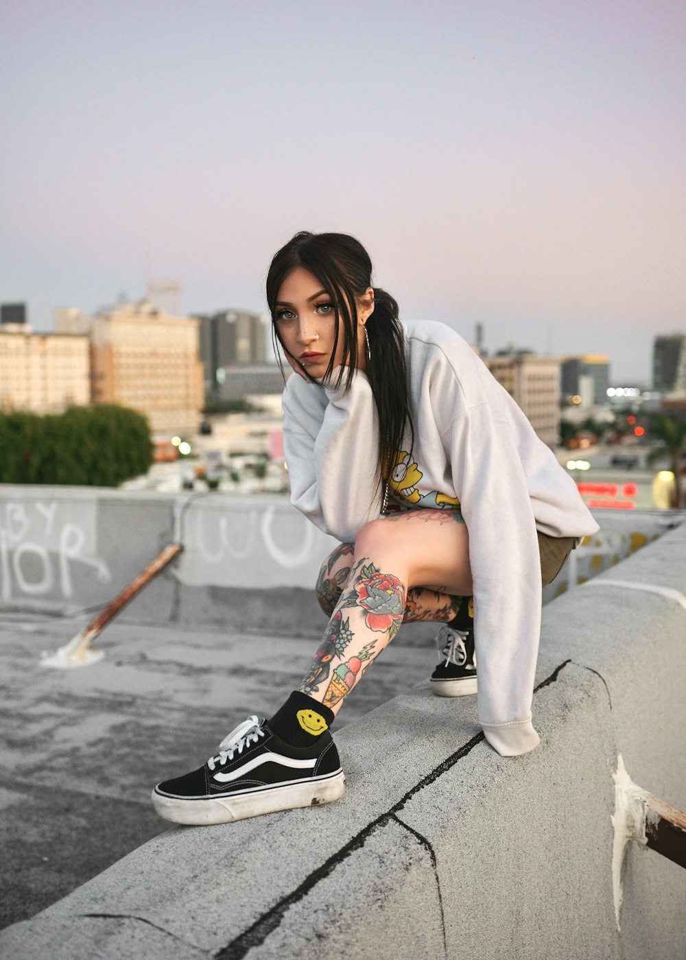 woman in white robe sitting on gray concrete pavement during daytime