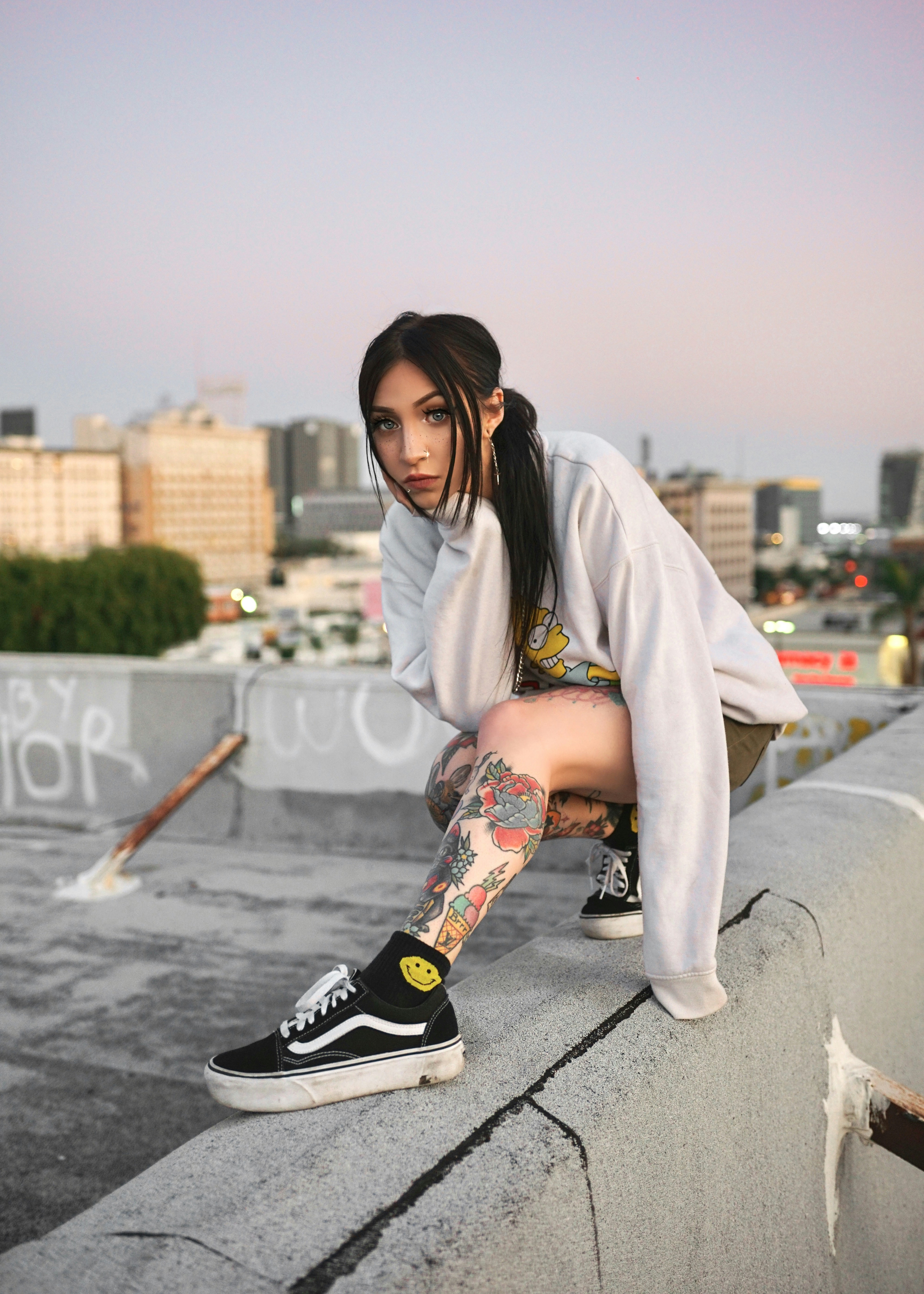 Tattooed girl model sitting on Los Angeles building rooftop at sunset Model: Jakiichu