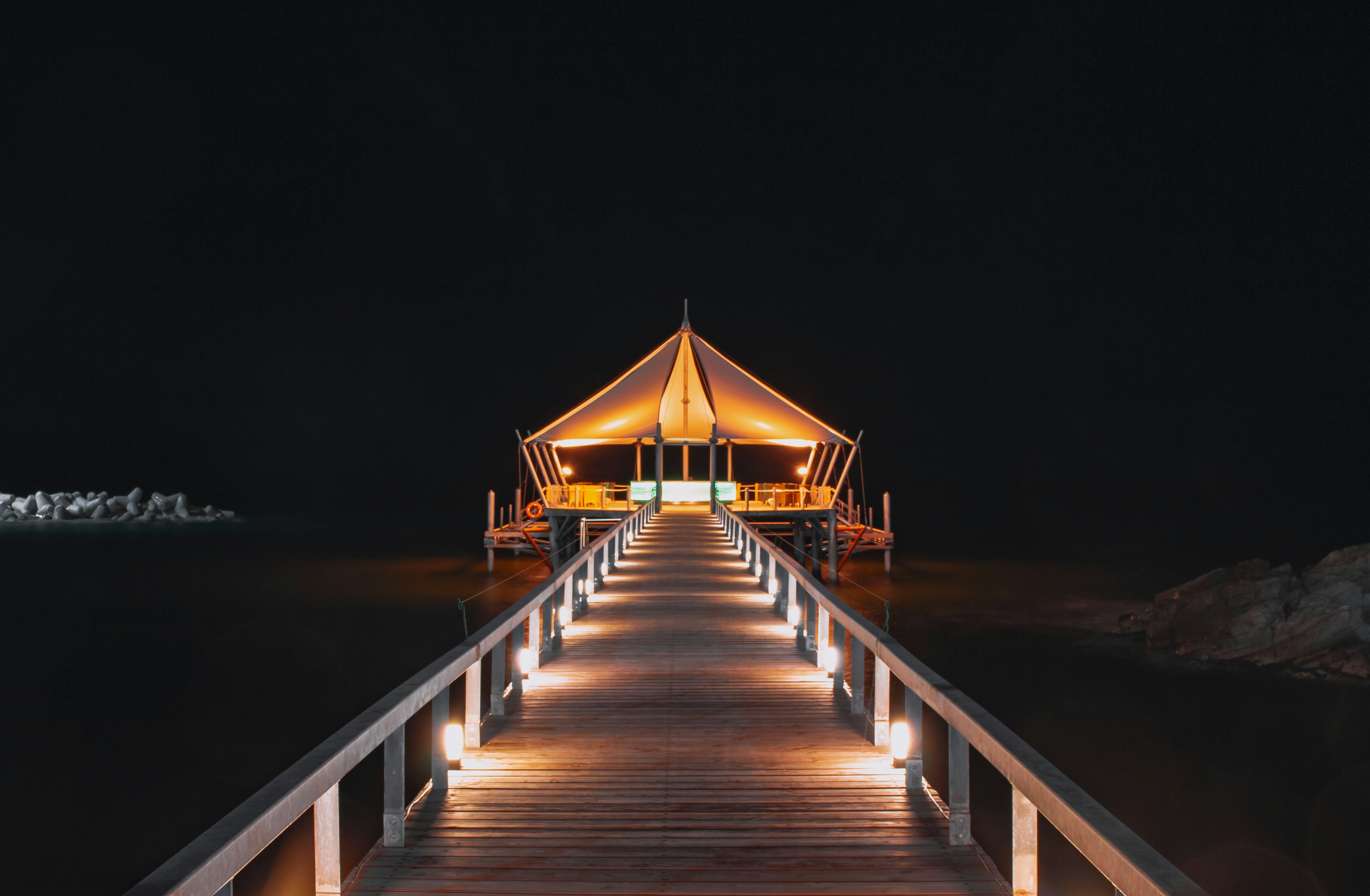 brown wooden dock with lights during night time