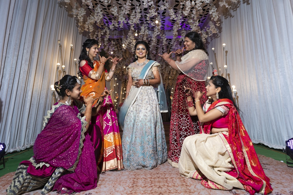 group of women in red and gold sari dress