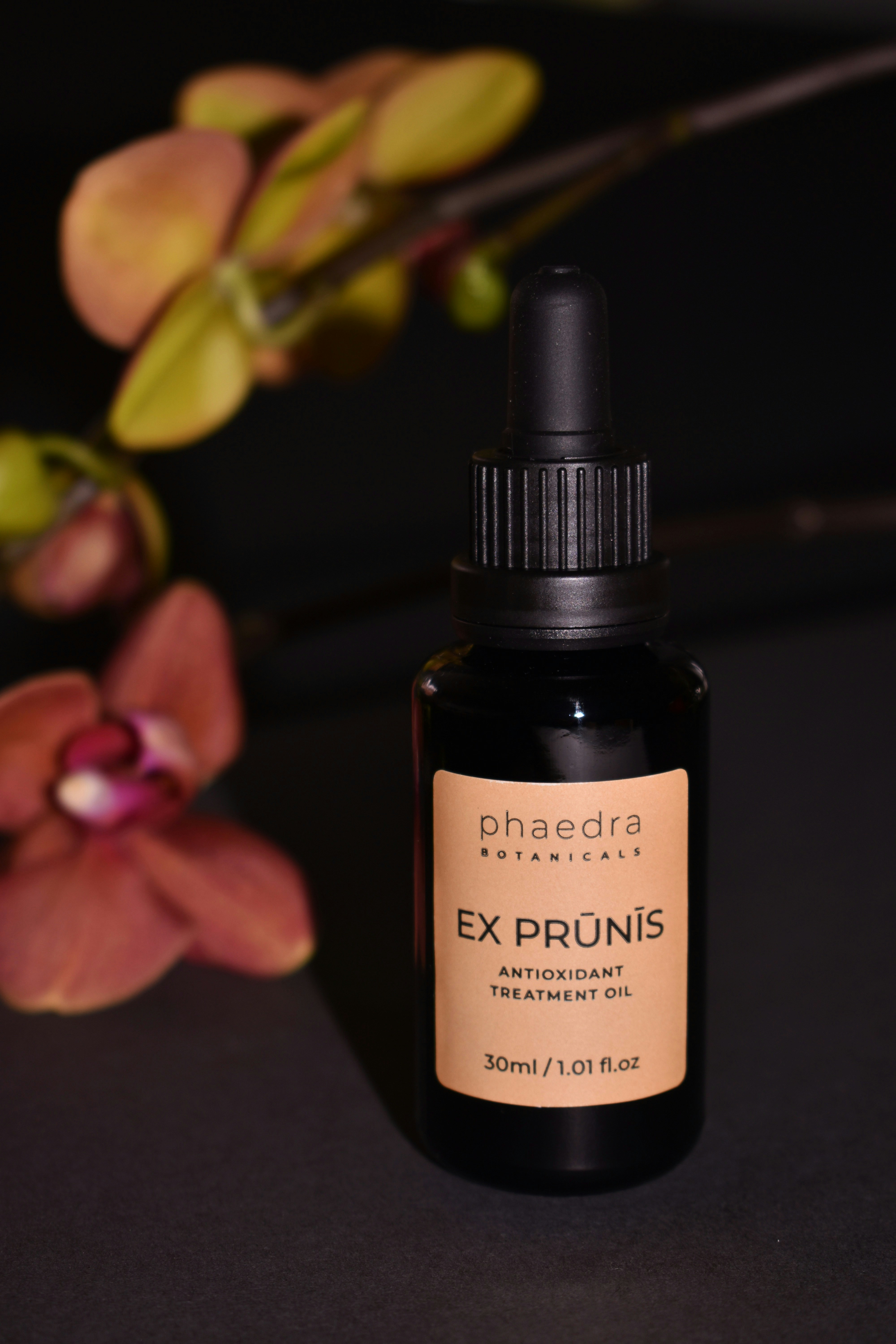 black glass bottle on purple flower