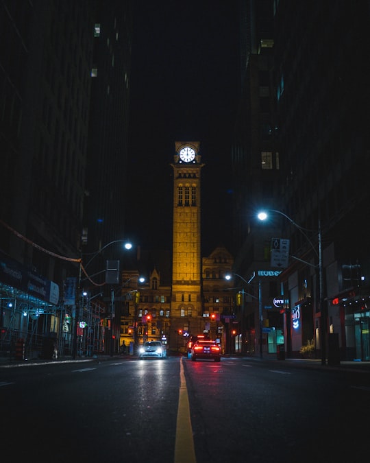 cars on road near big ben during night time in Old City Hall Canada