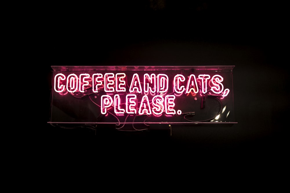 Un'insegna al neon che dice caffè e gatti per favore