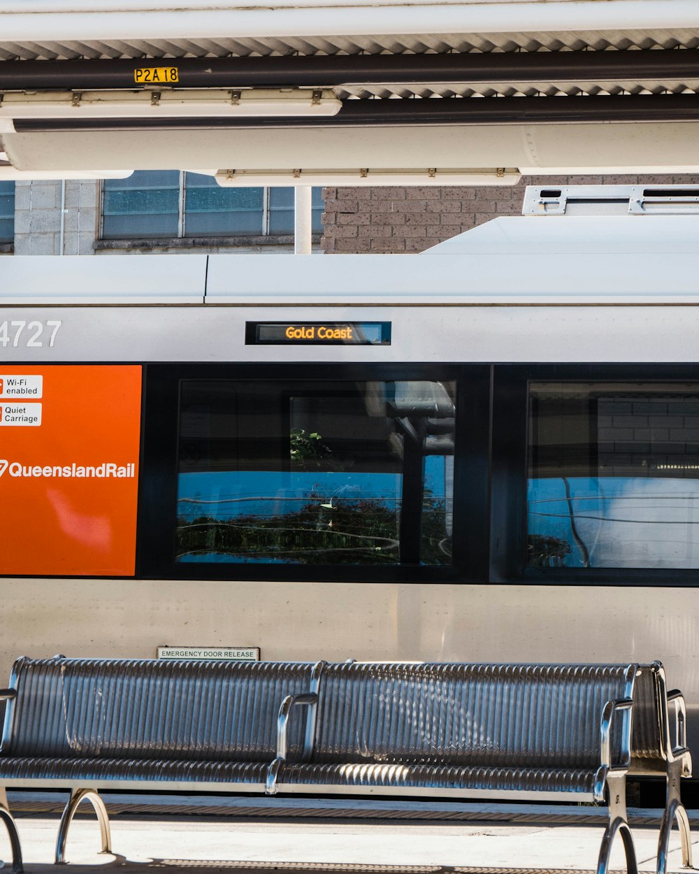 trem branco e laranja durante o dia