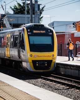 people standing beside yellow and blue train during daytime