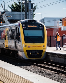 people standing beside yellow and blue train during daytime