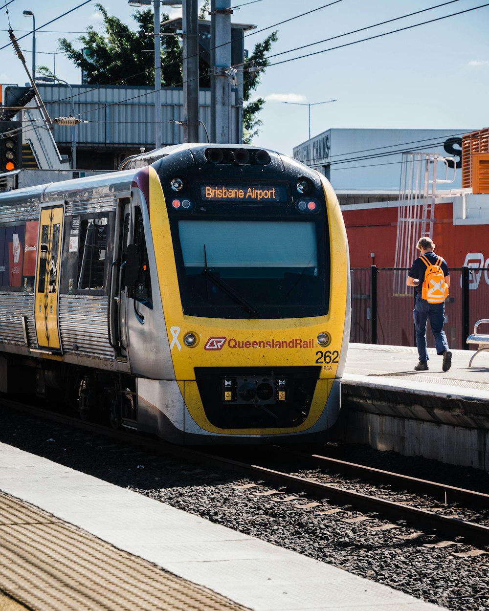 people standing beside yellow and blue train during daytime