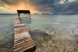 brown wooden dock on sea during sunset