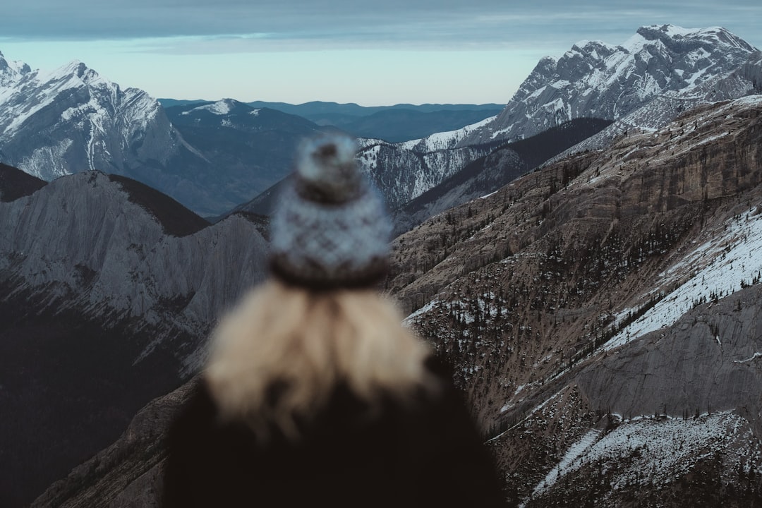 person in gray jacket standing on brown rock mountain during daytime