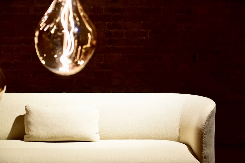 clear glass light bulb on white couch