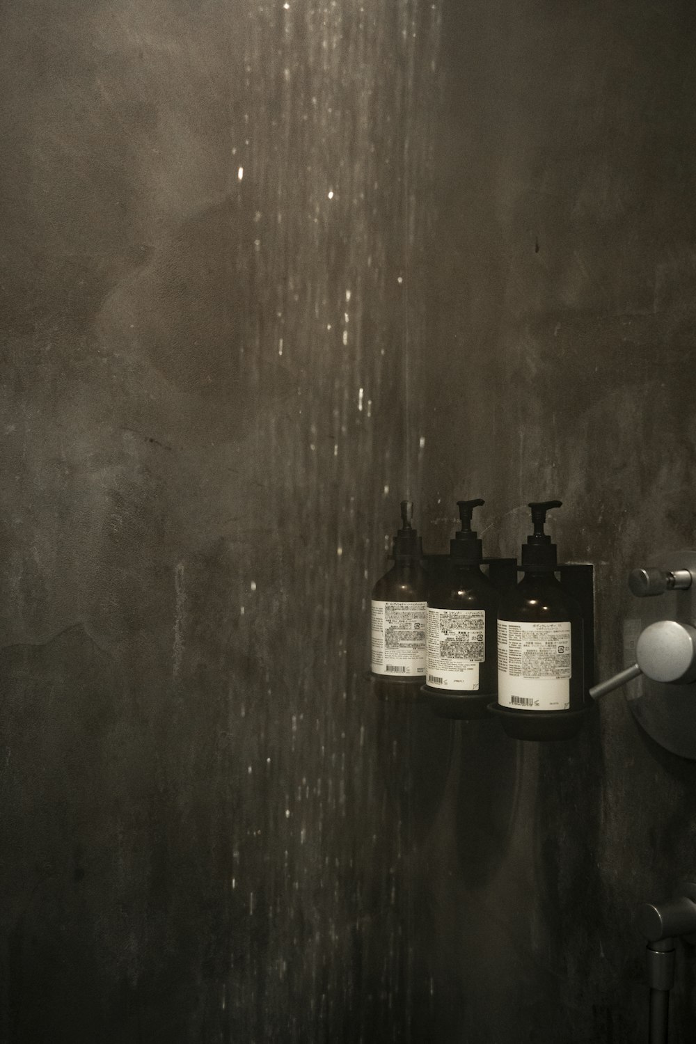 grayscale photo of bottles on wooden table