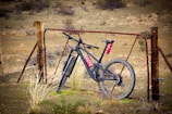 black and red mountain bike on brown grass field during daytime