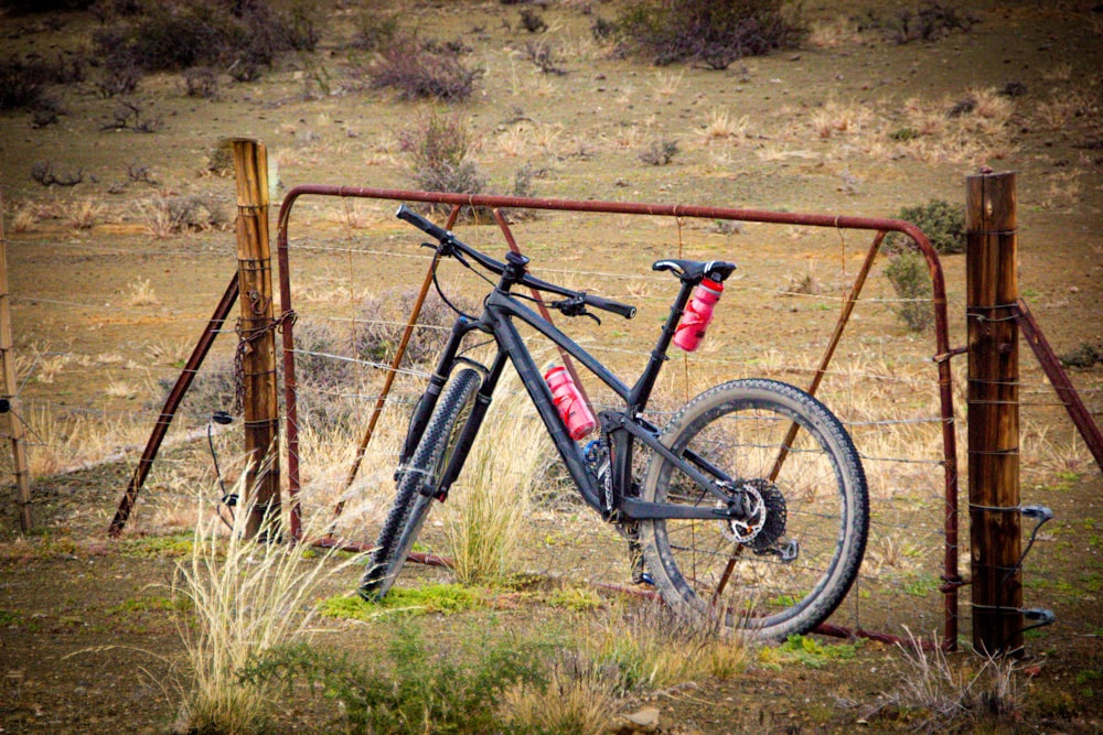 Bicicleta de montaña negra y roja en un campo de hierba marrón durante el día