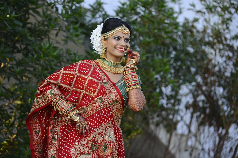 A woman in a red and gold sari talking on a cell phone