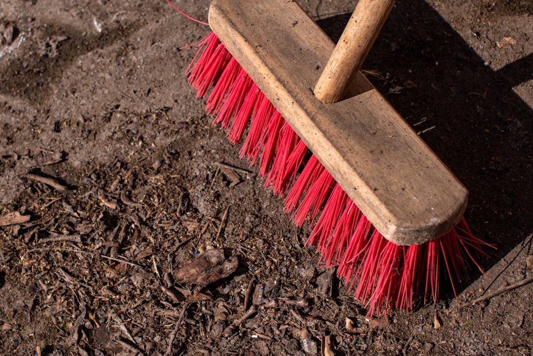  brown wooden handled brush on brown soil broom