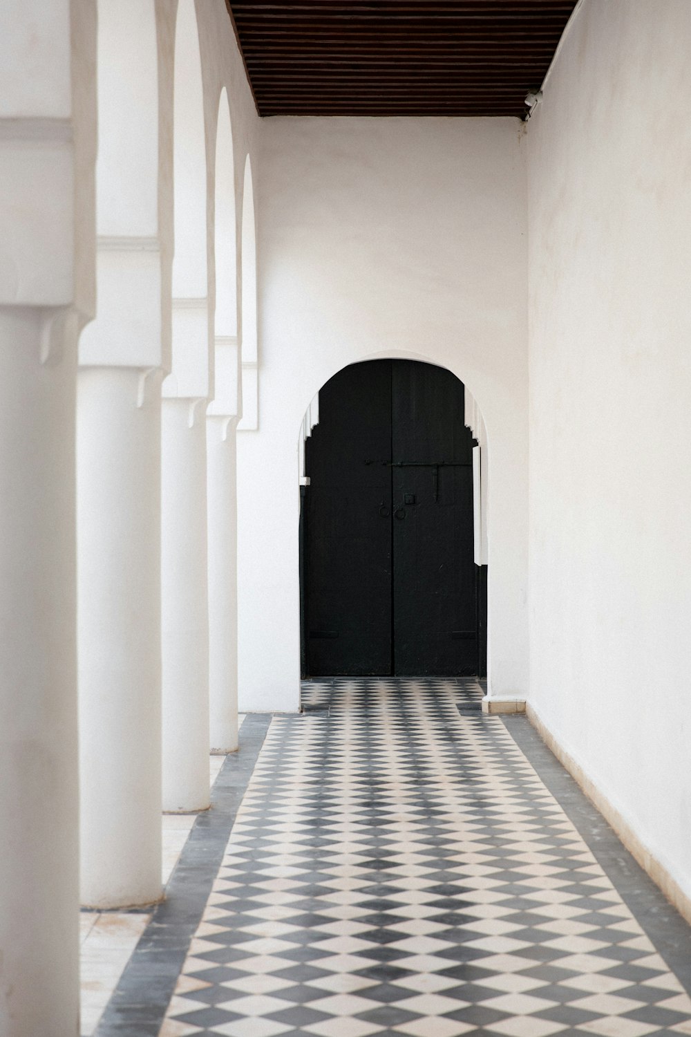 black wooden door on white concrete wall