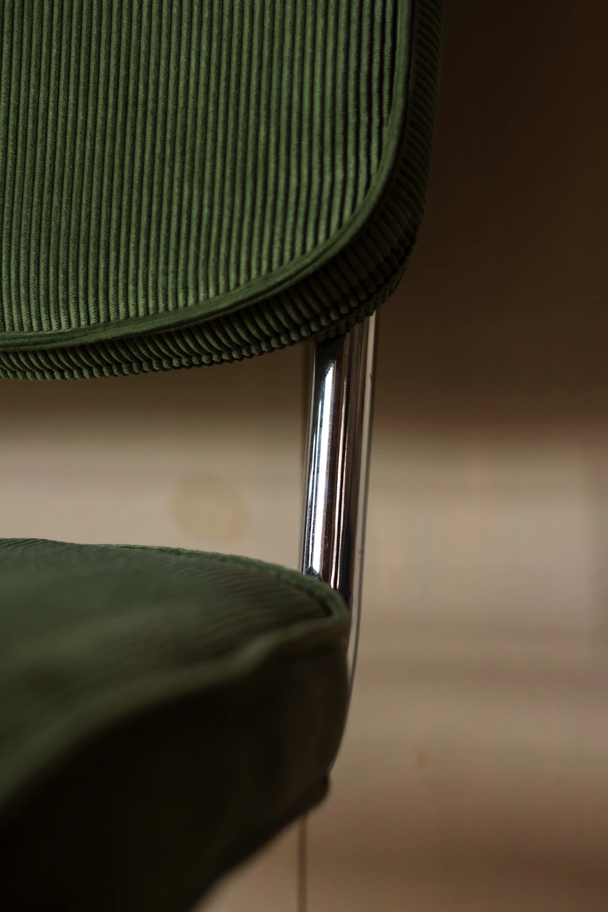 A green and black chair on a timber floor