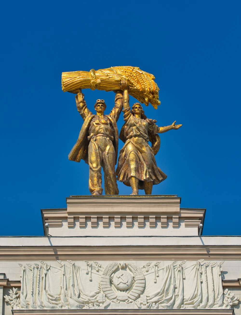 gold statue of man holding gold crown