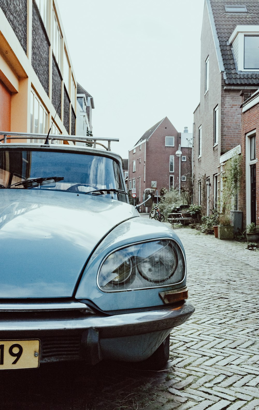 blue car parked beside brown concrete building during daytime