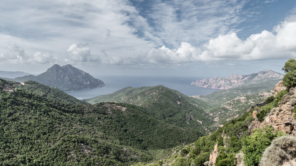 green mountains under white clouds and blue sky during daytime