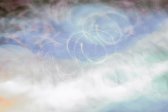 Soft pastel background with swirling galaxy and light energy patterns.