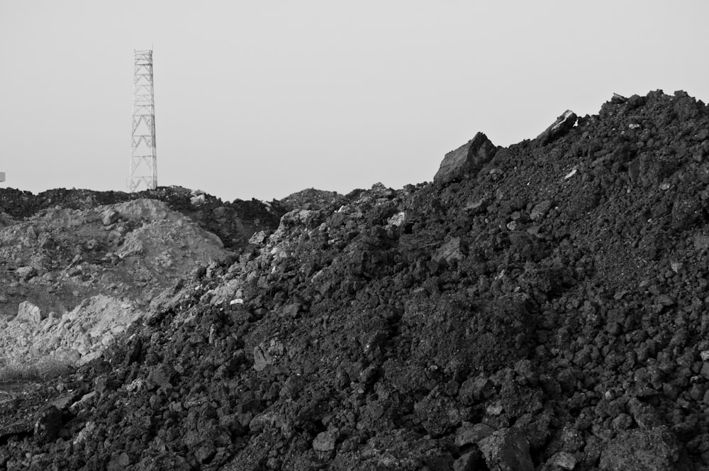 grayscale photo of mountain with tower