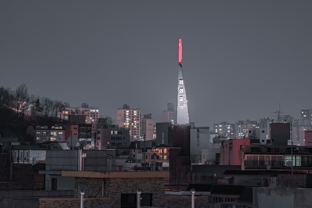 야간에 건물 꼭대기에 빨간색과 흰색 타워