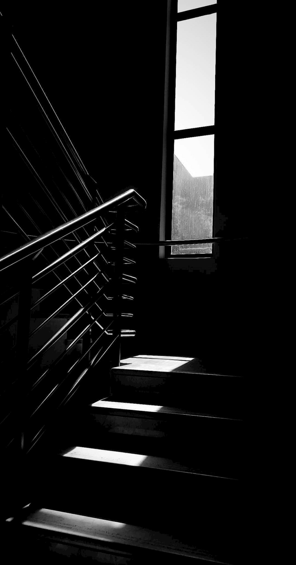 grayscale photo of staircase with metal railings
