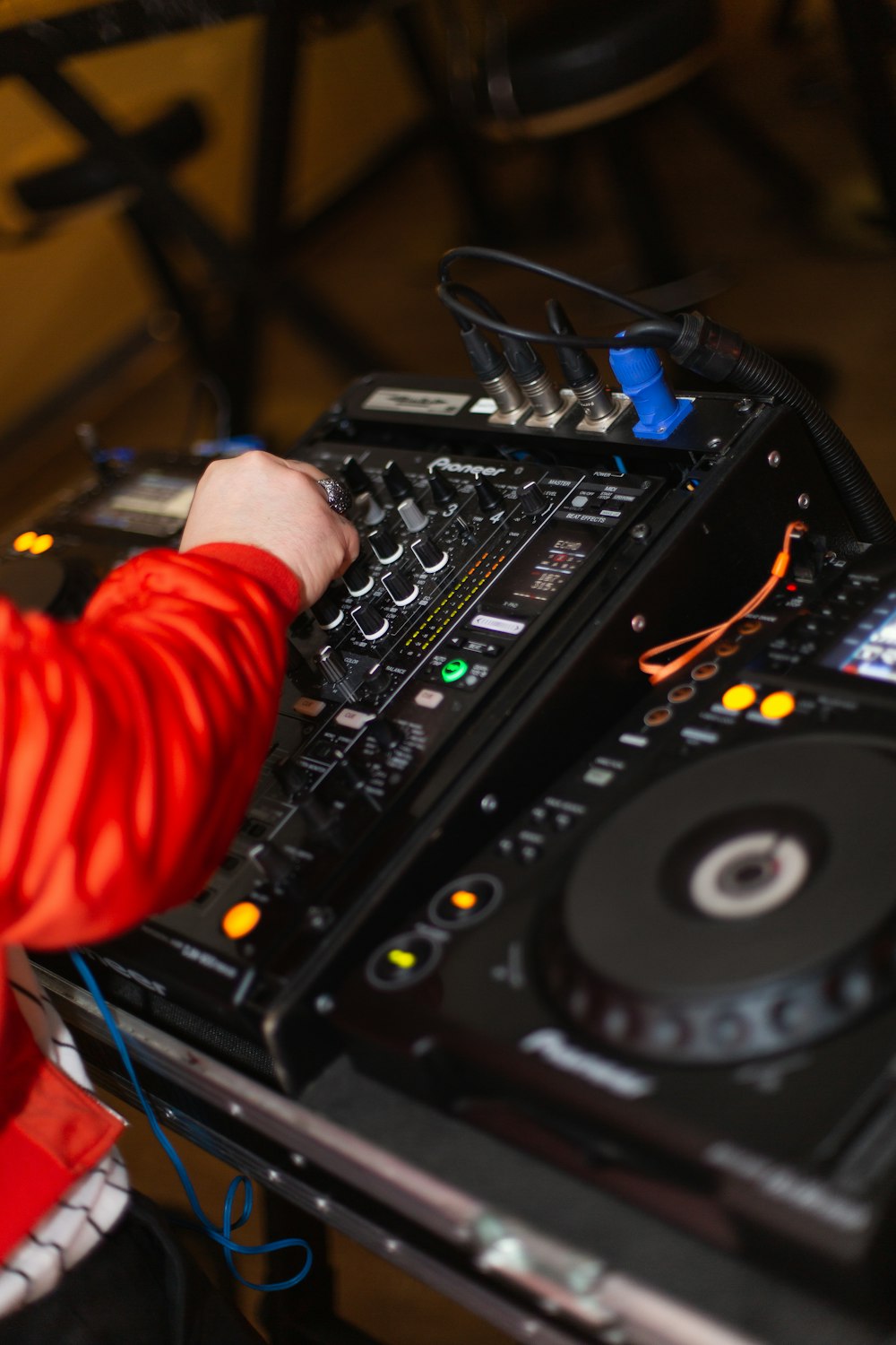 person in red long sleeve shirt playing dj controller